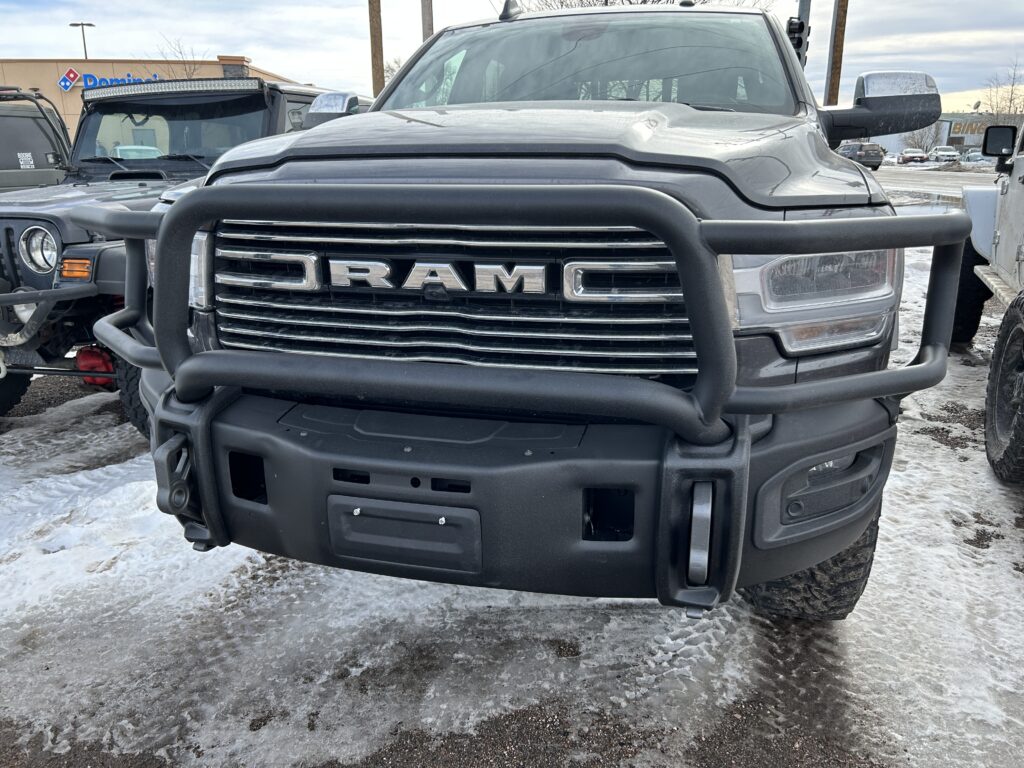 Heavy-duty black grille guard and bumper mounted on a RAM truck, providing maximum front-end protection.